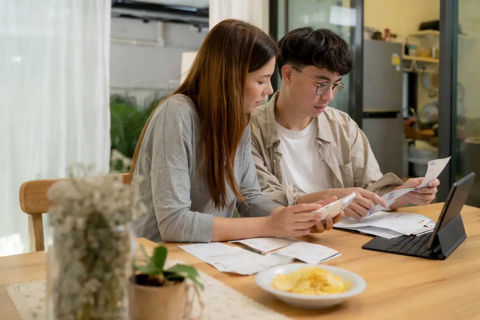 Banks control payment posting windows as a couple checks morning bank balances while reviewing deposits and pending payments