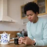 Woman checking bank app after confirmed deposit showing $0 balance in morning