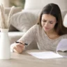 Woman reviewing household finances, reflecting financial responsibility anxiety in everyday life
