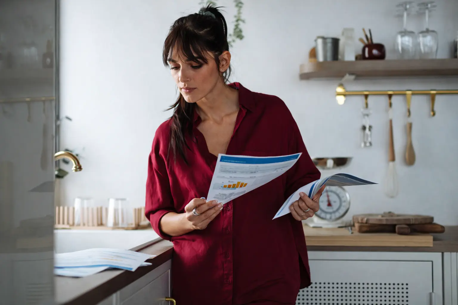 Woman reviewing financial documents at home, illustrating the hidden cost of always maintaining strict money discipline