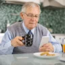 Senior checking bank balance on smartphone during Social Security payment day morning