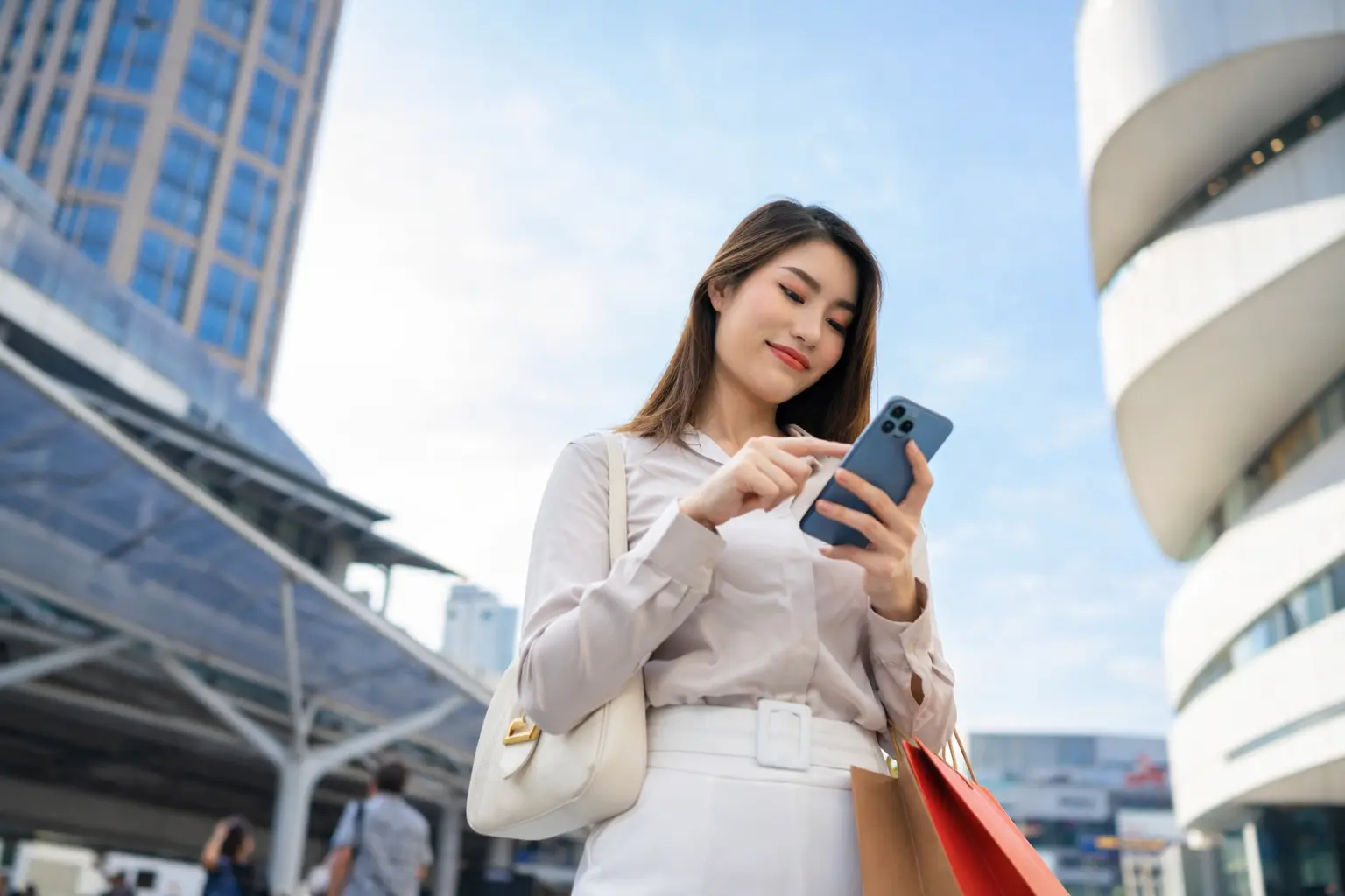 Woman checking a mobile banking app in the city as bank posting times today cause deposits to appear in accounts at different times