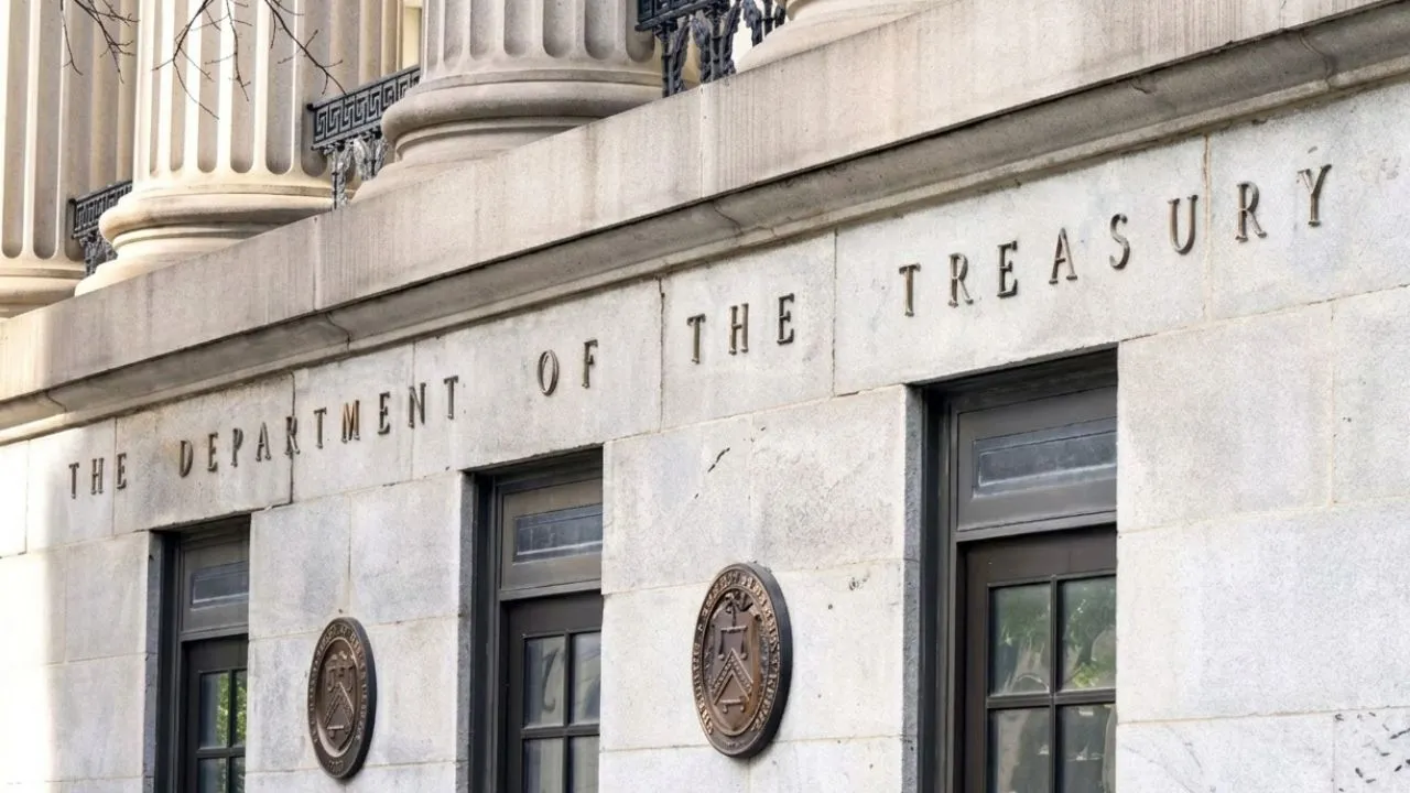 Financial analyst reviewing a 10-year Treasury yield curve chart on dual monitors in a professional office setting, representing the benchmark interest rate that drives global borrowing costs in 2026