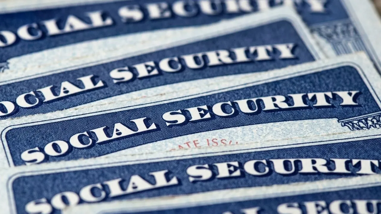 An older American woman sits at her kitchen table carefully reviewing a bank or benefit statement, concerned about how the Federal Reserve decision will affect her 2027 Social Security COLA increase