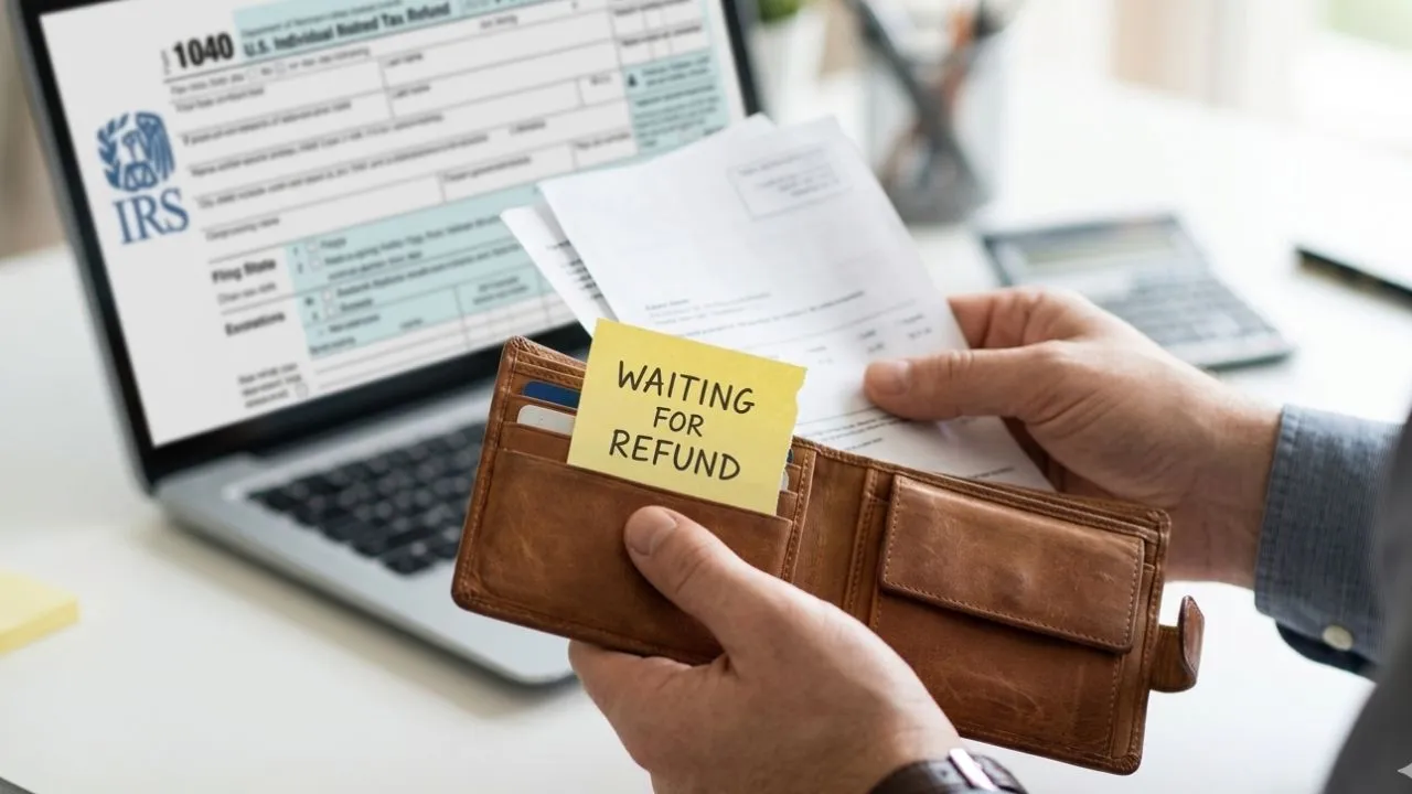 Person at a home desk looking at a laptop screen showing the IRS Where's My Refund tracker frozen on a status bar, representing a delayed tax refund in 2026