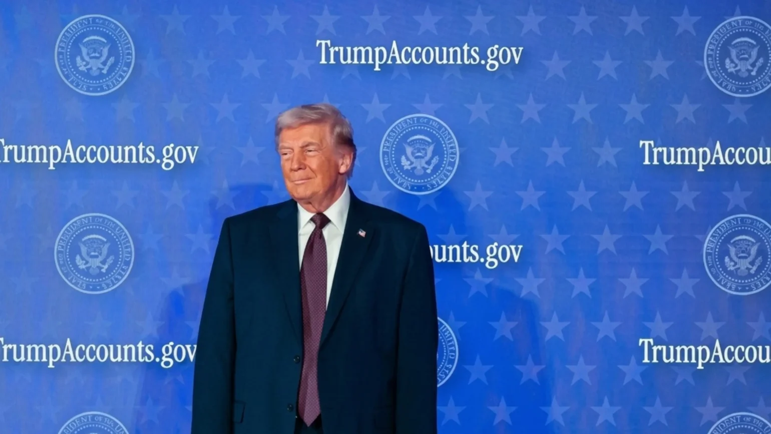 A parent holding a smartphone displaying the Trump Accounts app dashboard with a child's account balance and contribution options