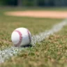 Baseball on a field representing a $50,000 Baseball Card and IRS rules for collectibles bought through an IRA.