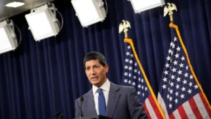 Latest U.S. Financial News and Analysis 19 Federal Reserve official speaking at a podium with U.S. flags behind him after Fed minutes showed broader support for higher interest rates over inflation concerns.