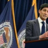 Kevin Warsh speaking at a podium with Federal Reserve flags behind him