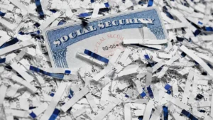 Latest U.S. Financial News and Analysis 25 Social Security card surrounded by shredded paper, illustrating the 2027 COLA outlook as inflation cools.