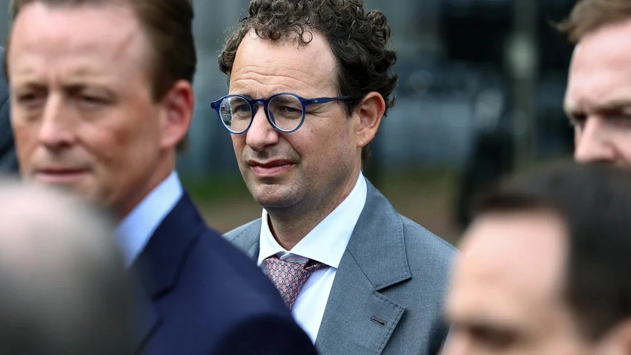 Anthropic executive pictured in a gray suit and blue glasses