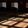 Voters cast ballots at voting booths inside a U.S. polling location