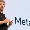 Mark Zuckerberg speaking at a Meta AI event with Meta AI branding displayed behind him