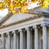 U.S. Treasury Department building in Washington, D.C., with stone columns and autumn foliage