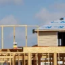 New home construction with wooden framing and a roofing worker, illustrating U.S. housing starts in September 2026.