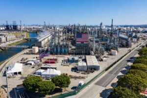 Latest U.S. Financial News and Analysis 8 Aerial view of a U.S. oil refinery with processing towers, storage tanks, pipelines and American flags.